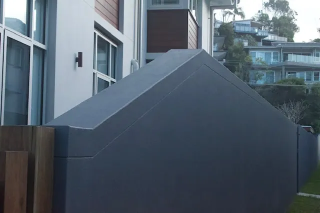 Charcoal acrylic rendered wall with crisp edges beside a modern home